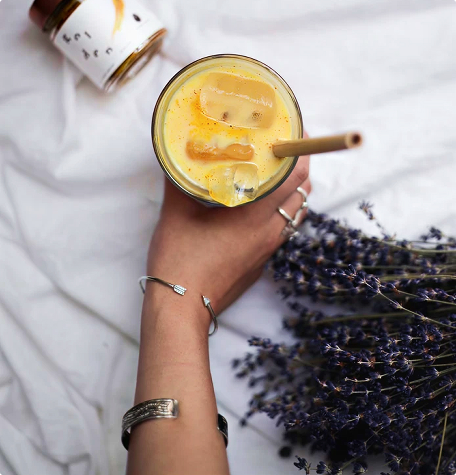 Golden latte glacé servi dans un verre avec glaçons et paille