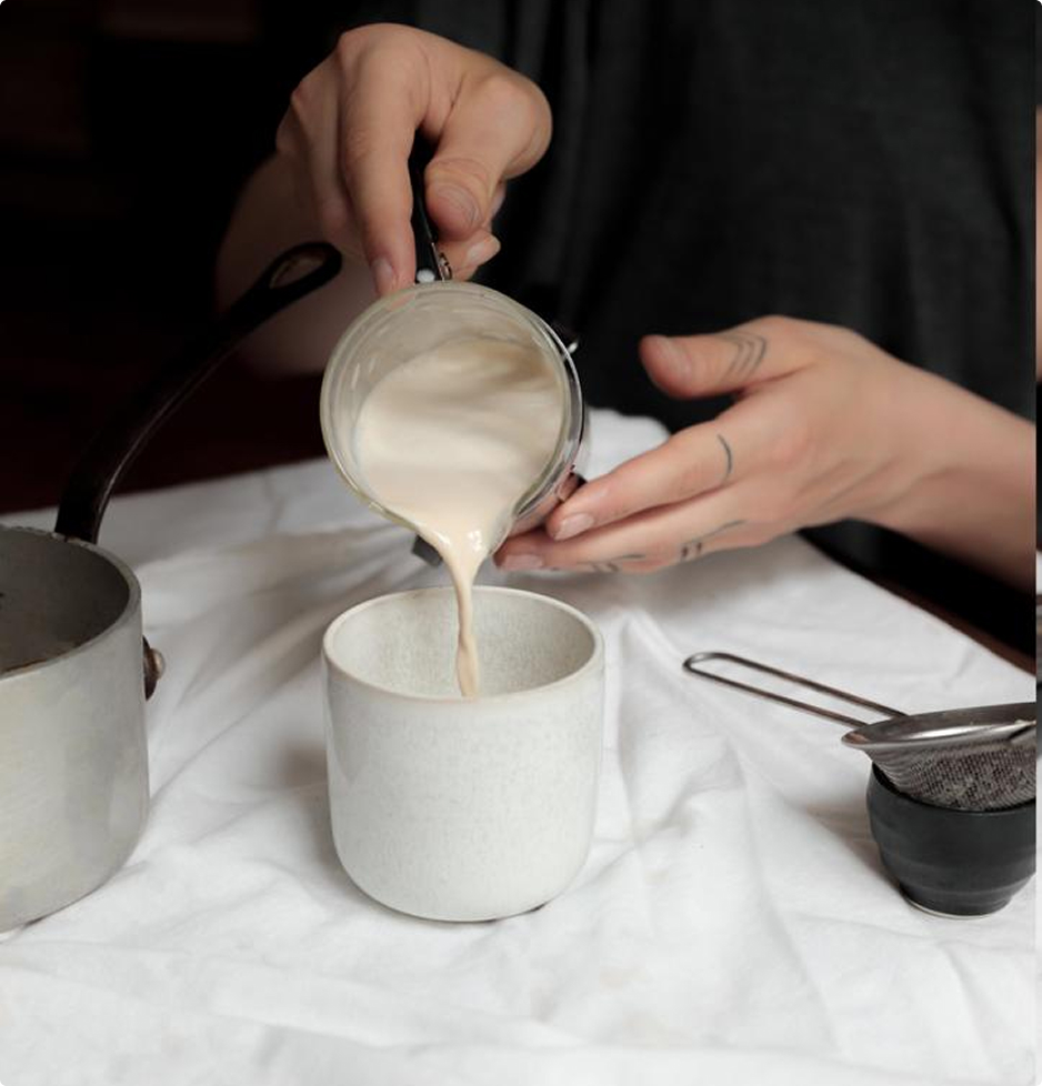 Versement de lait chaud dans une tasse lors de la préparation d’un green latte