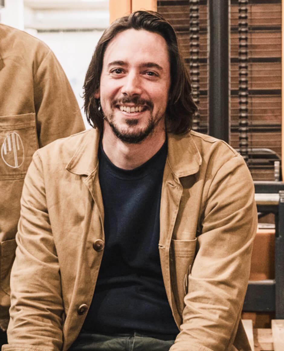 Personne assise souriante portant une veste claire dans un espace de travail