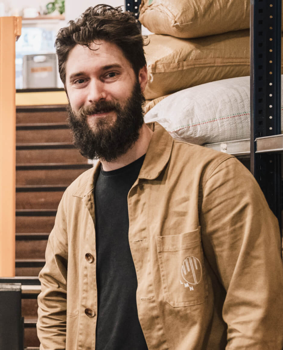 Personne debout dans un espace de stockage avec des sacs empilés en arrière-plan