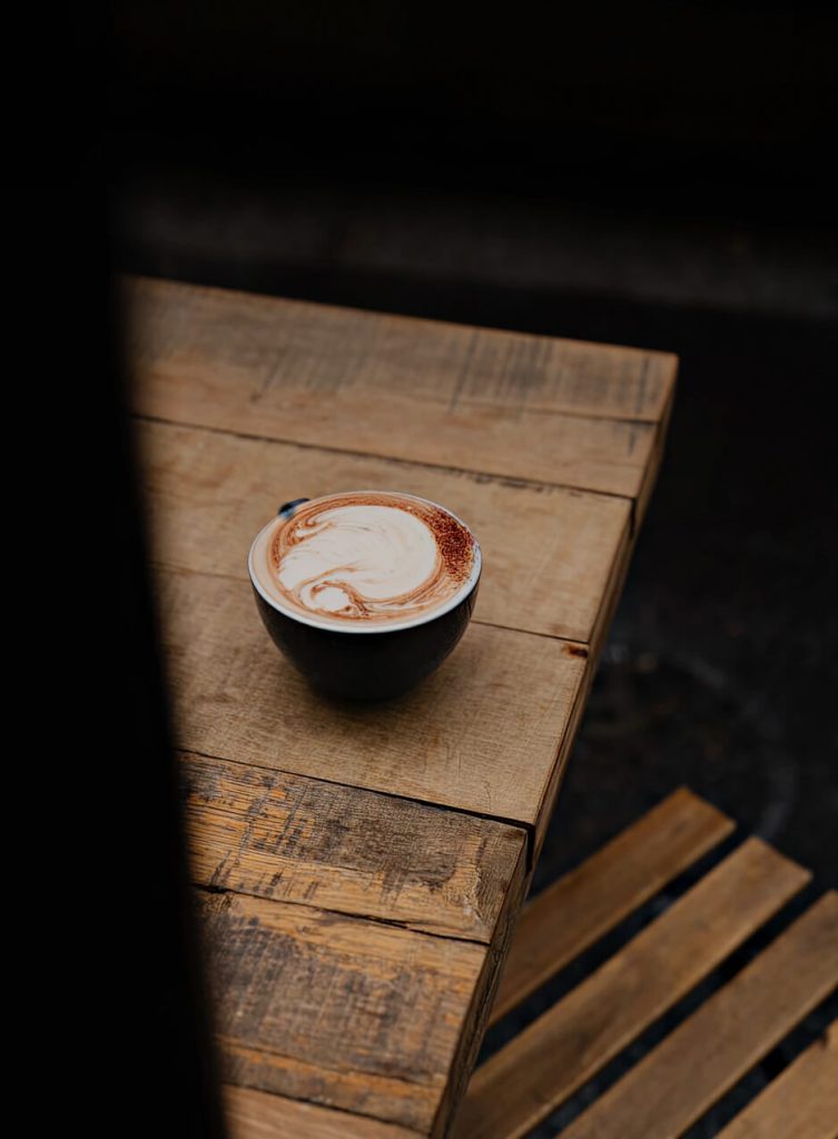Boisson au sticky chai servie dans une tasse posée sur une table en bois