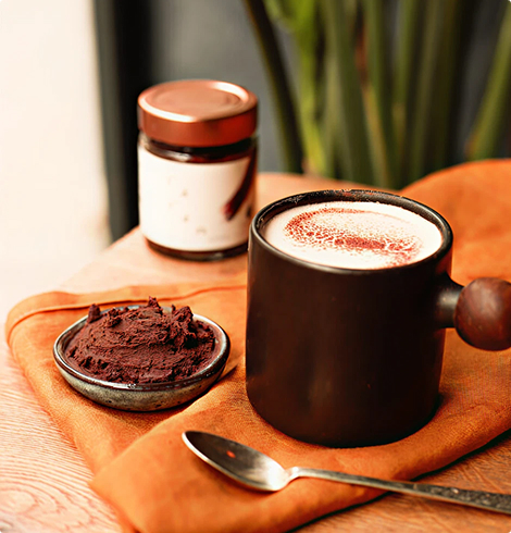 Tasse de boisson chaude accompagnée d’un pot et d’une pâte présentée dans un petit bol
