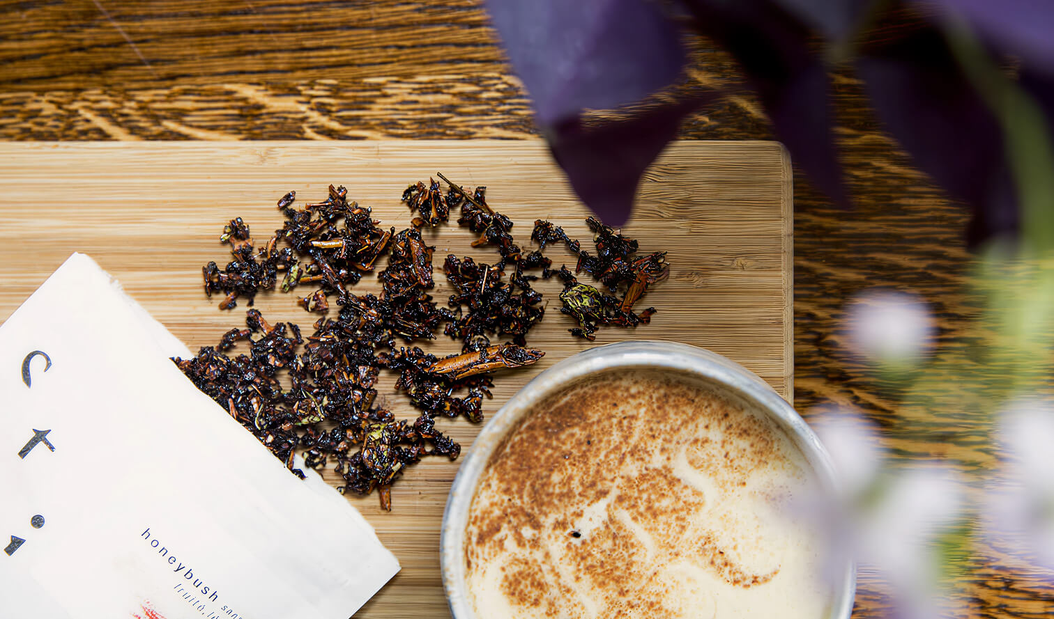 Préparation de honeybush avec feuilles de thé sur une planche et boisson servie dans une tasse